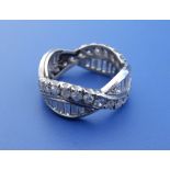 A diamond set white metal eternity ring of crossover design