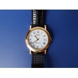 A gent's gold plated Gucci automatic wrist watch with date indicator on black leather strap – some