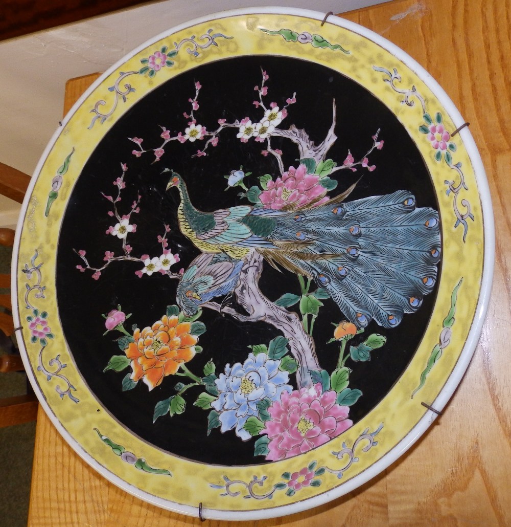 A Chinese black ground porcelain charger decorated exotic birds