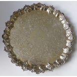An engraved silver salver with family coat of arms to centre, the reverse inscribed 'Presented by
