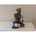 An Oriental stoneware figure of a seated man reading