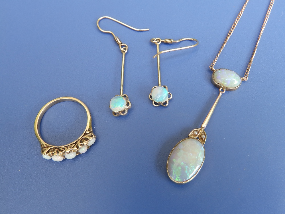 An opal pendant necklace, a pair of opal drop earrings and an opal five stone ring. (4)