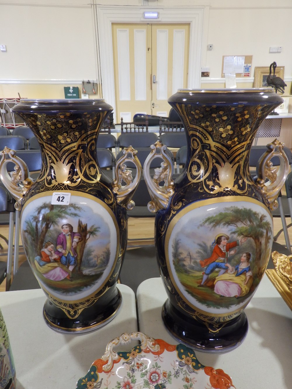 A large pair of 19thC continental porcelain two=handled vases, each decorated with an oval panel