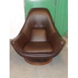 A 1960's 'High Society' revolving chair to a design by Peter Cutts, re-upholstered in dark brown