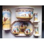 An eight piece Falcon Ware dressing table set decorated with an arab on camel pattern.