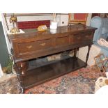 An oak low potboard dresser, having brass rail back over three drawers on turned legs, Height 46.5”,