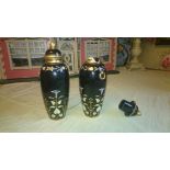 A pair of black glazed terracotta covered vases, painted with a formal pattern depicting morning