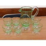 A seven piece green glass drinking set.