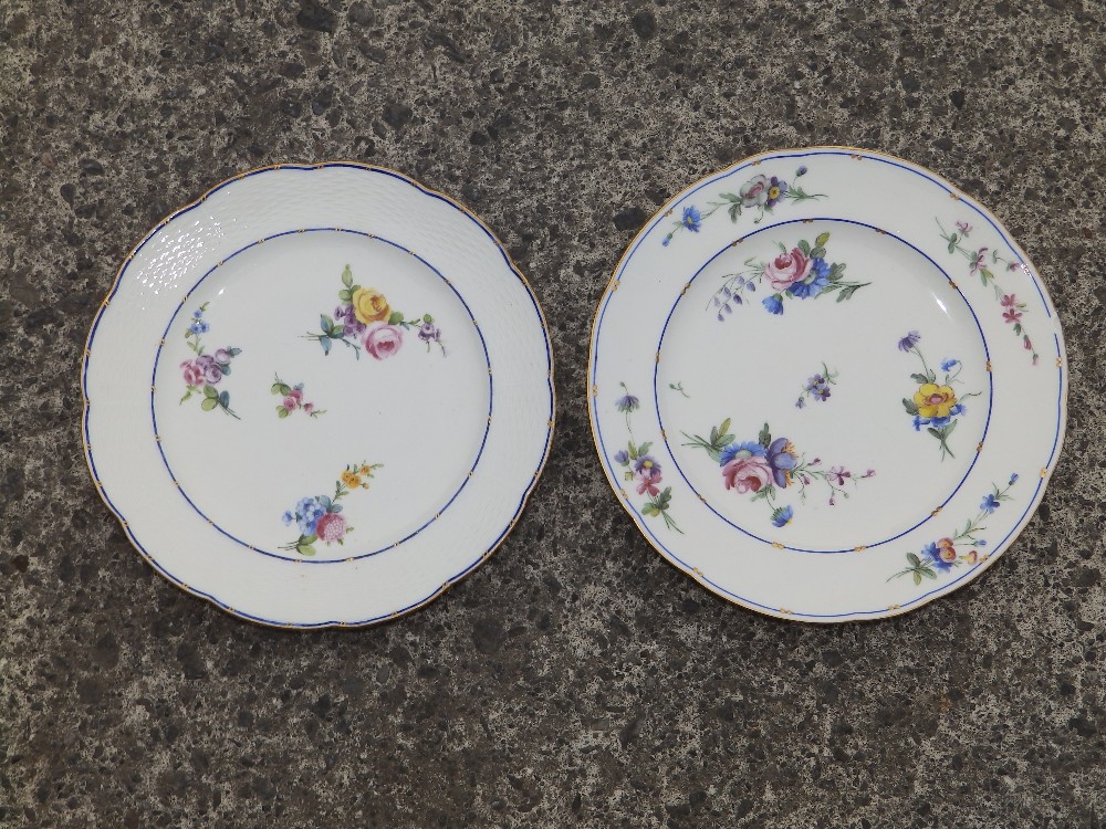 Two similar floral painted porcelain plates – interlaced 'L' marks in blue – one chipped.