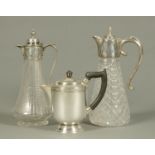 Two glass claret jugs, one engraved and cut, the other moulded, and a silver plated hot water jug.