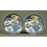 A pair of Japanese Imari chargers, principally blue and white, figures, boat, building and birds.