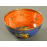 A Wedgwood orange and purple lustre fruit bowl, decorated with fruit. Diameter 23 cm.