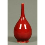 An early 20th century bottle shaped vase, with burgundy ground, indistinct impressed mark to base.