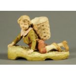 A Royal Dux figure, young boy with basket. Length 25 cm.