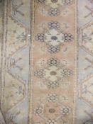 A Caucasian rug with stylised floral and geometric designs in salmon, pale blue,