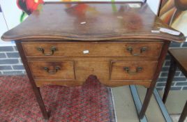 A George III mahogany low boy, the top with serpentine front over one long and two short drawers,