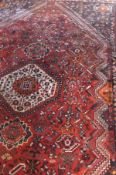 A Shiraz carpet, the central diamond shaped medallion in cream, red,