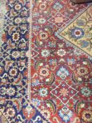 A Persian carpet, the central diamond shaped floral decorated medallion in pale gold, blue and red,