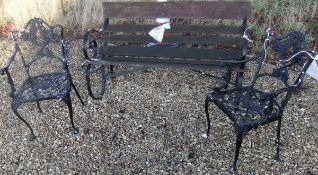 A hardwood slatted garden bench with wrought iron end supports,