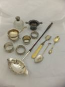 A box containing assorted silver wares to include a Georgian toddy ladle, various napkin rings,