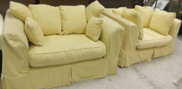 Two small modern sofas with pale yellow damask loose covers,