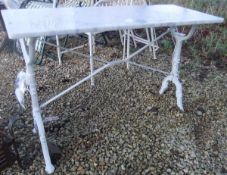 A white marble topped rectangular table with painted wrought iron base