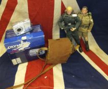 A basket containing two Action Man dolls, wearing combat fatigues, another similar doll,
