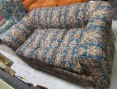 An early 20th Century Chesterfield style three seat settee with printed floral loose covers