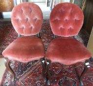 A pair of Victorian rosewood framed and buttoned upholstered dining chairs on cabriole front legs