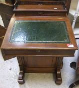 A late Victorian walnut Davenport with stationery compartment over a sloping fall and four drawers