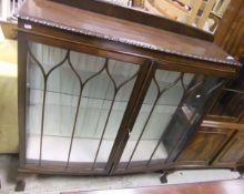 A 1920's mahogany bow fronted display cabinet with two doors and three glazed shelves on claw and