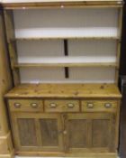 A pitch pine dresser with two open shelves raised on a base of three short drawers and two cupboard