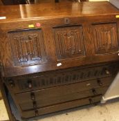 An oak bureau with linenfold decoration to the fall, a green painted pine side table,