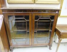 An early 20th Century mahogany display cabinet, the top with gadrooned edge above two astragal