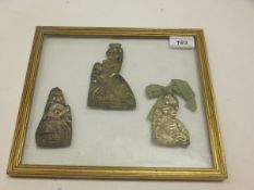 Three silvered copper pilgrim badges (housed in a glazed frame)