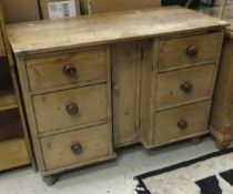 A Victorian pine dresser with single central narrow cupboard door and six drawers CONDITION
