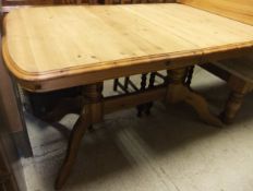 A late 20th Century pine rectangular extending dining table on twin pedestal base united by a