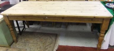 A modern rectangular pine farmhouse kitchen table on four turned legs