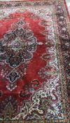 WITHDRAWN A Persian rug, the central motif in black, burgundy, cream,