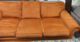 A large modern three seat sofa upholstered in dark orange chenille type fabric