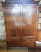 A 19th Century mahogany linen press with two cupboard doors enclosing a hanging space, over two