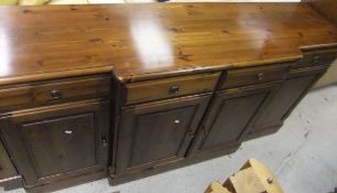 A 20th Century pine breakfront sideboard with four drawers and four cupboard doors to plinth base