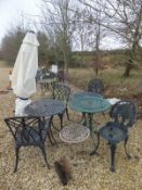 A collection of three cast metal tables together with two pairs of chairs,