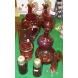 A collection of cranberry glassware to include two liqueur decanters, two sugar shakers, water jug,