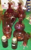 A collection of cranberry glassware to include two liqueur decanters, two sugar shakers, water jug,