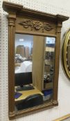 A rectangular wall mirror in a gilt effect frame with applied moulded decoration to top