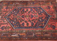 A 20th Century Caucasian rug, the central medallion in dark blue, terracotta,