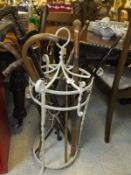 A white painted wrought iron six section umbrella / stick stand and 14 various sticks