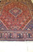 A Persian carpet, the central diamond shaped medallion in dark blue, terracotta and cream on a