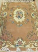 A Chinese superwash carpet, the central floral medallion in cream, pink and blue on a salmon ground,
